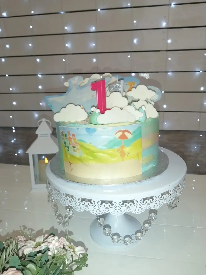 Torta de primer año con un número uno rosa y nubes de azúcar
