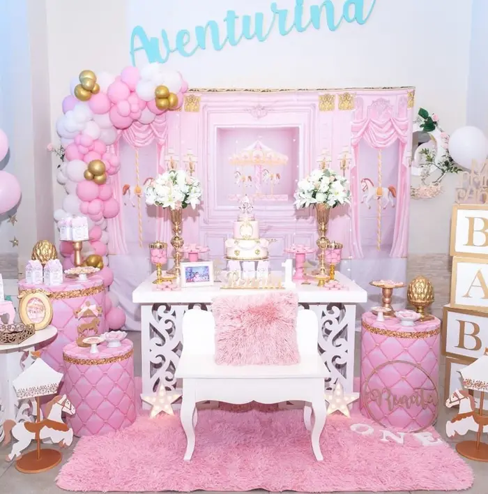 Mesa principal en rosa y blanco con arco de globos rosas y cubos de letras