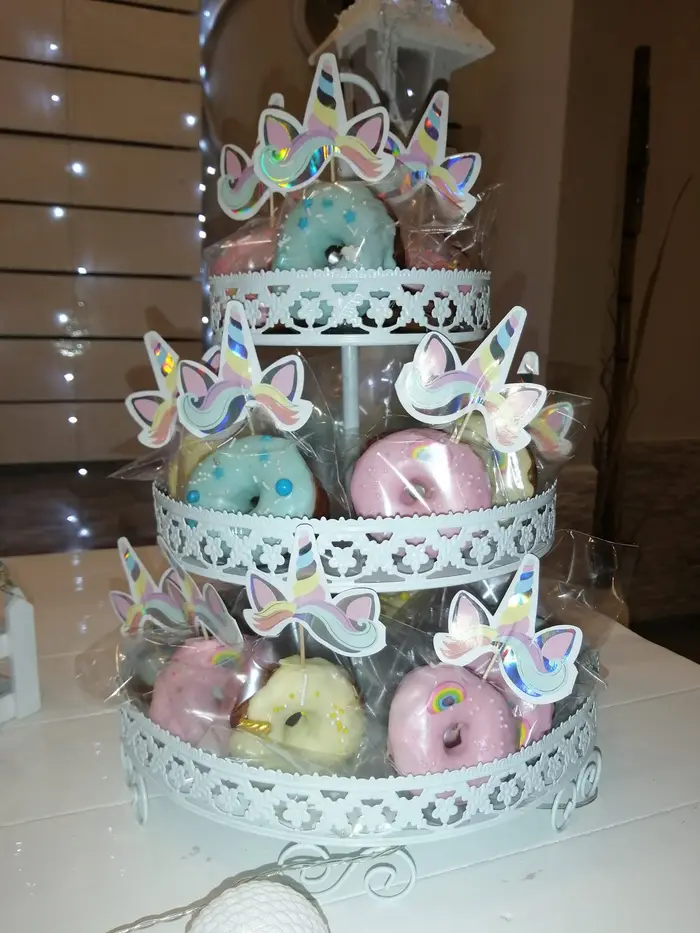 Bandeja de tres pisos con donas decoradas con unicornios